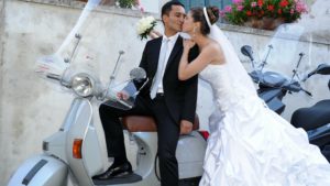 Mediterrane Hochzeit Paar küssend auf Vespa